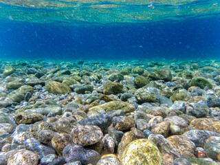 Vista del fondale pieno di sassi del mare mosso