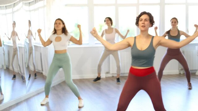 Group of women rehearsing modern dance moves in studio