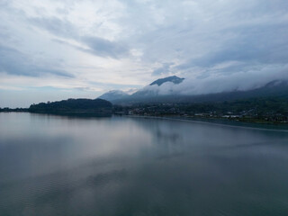 Serene lake with misty mountains at dusk