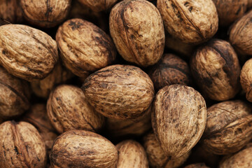 Heap of walnuts in shell, close-up, top view. Healthy eating. Harvest, agriculture. Walnuts, selective focus, background