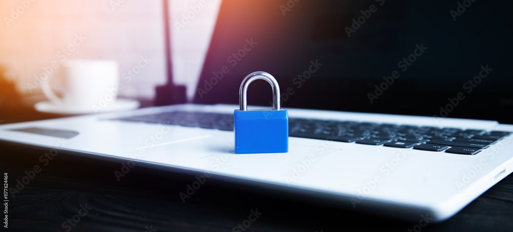 Aufkleber laptop computer on desk with padlock on table.