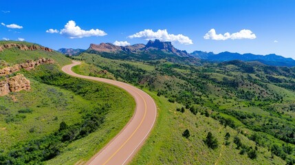 Scenic Curvy Road Through Lush Green Hills Under Blue Sky