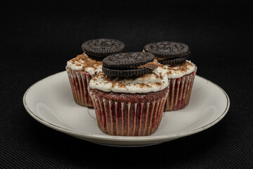 close up of various sweet cupcakes on cake stand isolated on black