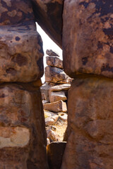 Looking through a gap in the rock formations at a tower of stacked boulders in the Giant&rsquo;s Playground of southern Namibia.