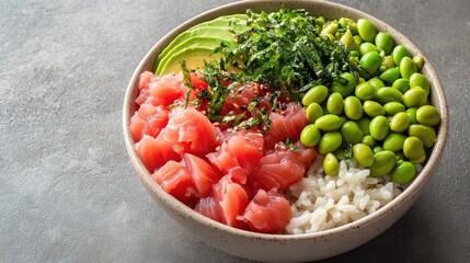 overhead photo of tuna poke bowl with fresh avocado edamame and rice presented on neutral backdrop with 70 copy space
