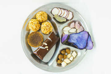 A Plate of jaggery, sesame balls, yam, sweet potato for Maghe Sankranti Festival or Pre Workout Meal