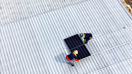 A sustainable energy project featuring solar panels on a roof surrounded by tropical trees,...