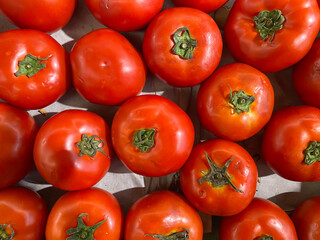 A pile of fresh ripe red tomatoes in the supermarket. Flat lay setup