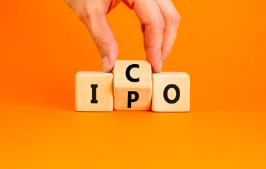 Initial public or coin offering symbol. Concept words abbreviation IPO or ICO on wooden block. Beautiful orange table orange background. Business Initial public or coin offering concept. Copy space.