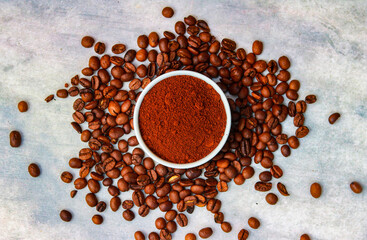 Coffee beans and coffee powder in a white bowl on a white background