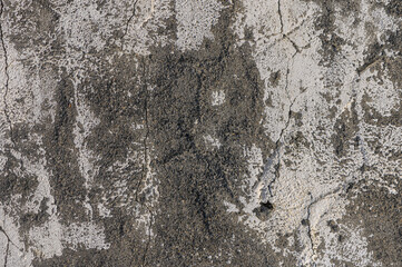 Weathered concrete surface reveals intriguing textures and patterns over time in an urban...