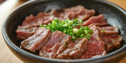 Beautifully arranged slices of tender beef served in a bowl, garnished with fresh green onions.