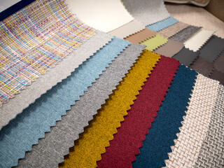 Catalog of fabrics for upholstered furniture. Samples of multicolored fabrics. Choosing the color of the sofa. Background for the textile industry.