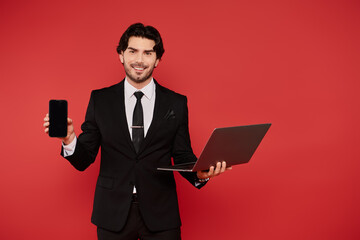 Young handsome man showcases technology in a vibrant studio setting