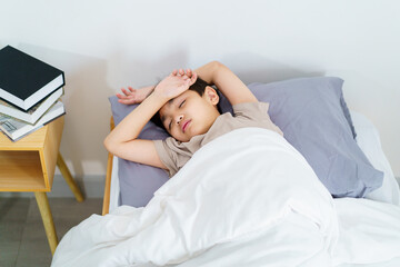 Asian little boy wakes up in morning.