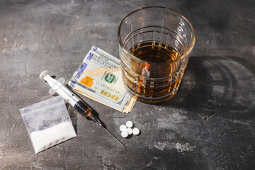 White narcotic pills, an alcoholic drink in a glass, syringe with a dose of heroin, cocaine powder...