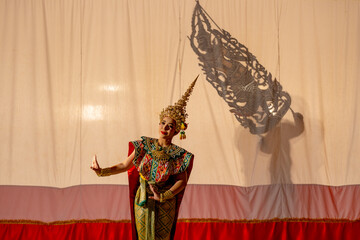 One woman with Khon or Mask dance dress stand with performance action in front of grand shadow play...