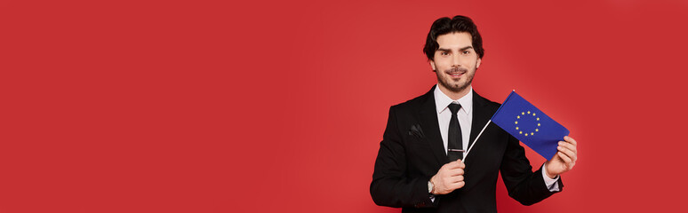 Confident young man showcasing European Union flag with pride in a vibrant studio setting