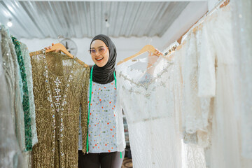 An exceptionally happy woman proudly showcasing beautiful and vibrant traditional dresses