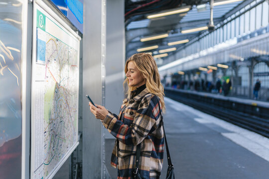 Woman Checking Map at Metro Station