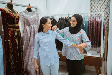Obraz premium In a vibrant fashion studio, two women communicate during a detailed dress fitting