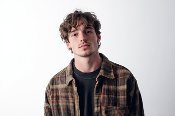Obraz premium Stylish Young Man with Curly Hair Posing Against a Simple Background