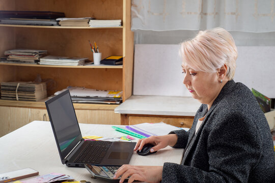 Accountant working at a laptop in the office among documents