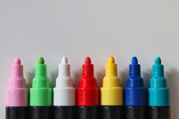 Colorful marker pens arranged in a row on a white background