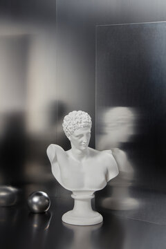 Marble bust of man next to gray sphere in corner of chrome studio