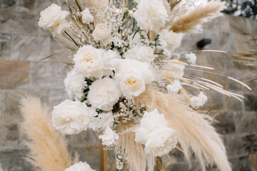 Beautiful wedding floral decorations with white roses and pampas grass