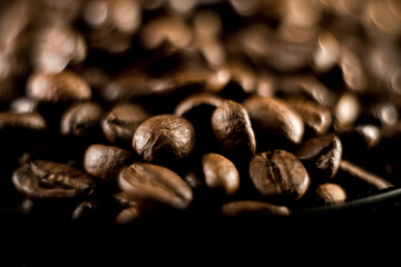 Close-up view of coffee beans on black background highlighting rich texture and color in fresh coffee detail