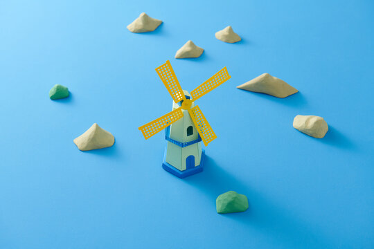 Colorful Toy Windmill and Rocks on blue Background