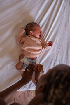 Mother changing diaper of crying baby