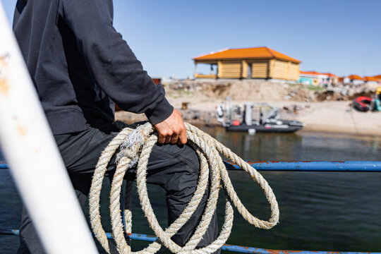 Sailor Is Waiting To Park Sea Boat With Rope