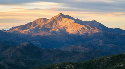Scenic mountain range with a vibrant sunrise casting golden light over the peaks