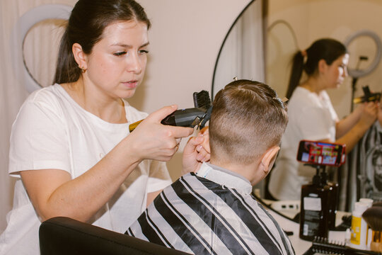 barber cuts a boy's hair