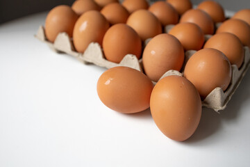 Chicken eggs in a paper tray side view with white background