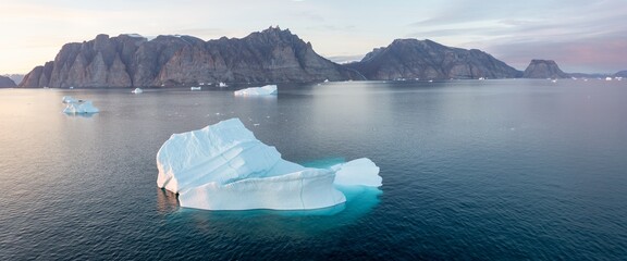 Big icebergs in Atlantic ocean, Ilulissat icefjord, western Greenland. Blue sea and the blue sky at sunrise.
Melting icebergs by the coast of Greenland, on a beautiful summer day. Global warming
