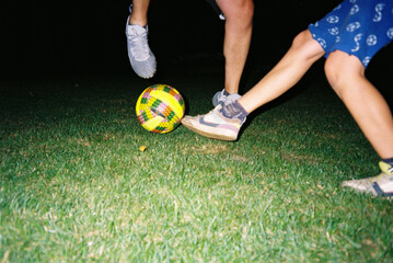 Two players engaging in a lively soccer game at night