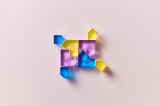 Composition of glass colorful hearts and pentagons on beige background