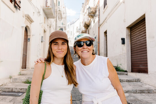 Mid-range portrait of a mother and her daughter posing in Ostuni town