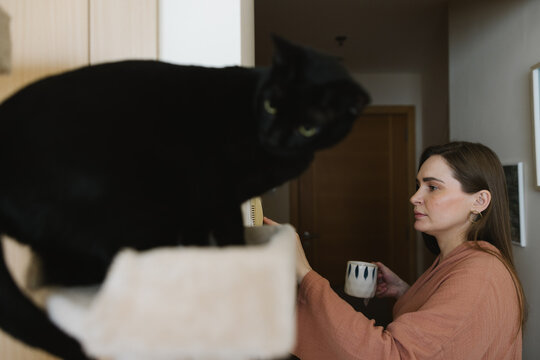 A woman turning on the AC at home