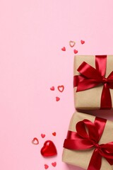 Beautiful gift boxes with red hearts and paper card on color background
