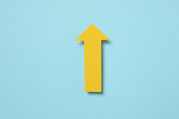 Paper arrow on color background, top view