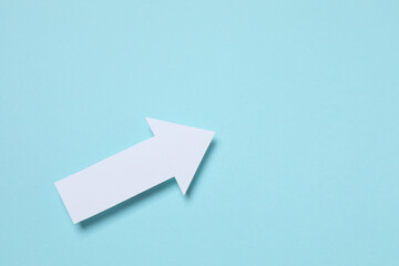 Paper arrow on color background, top view