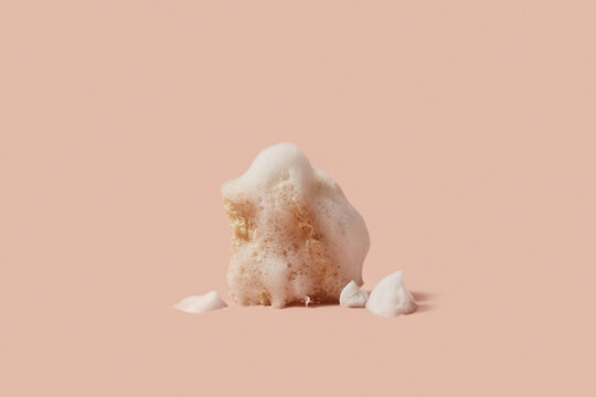 Scrub sponge covered with lush white foam in studio