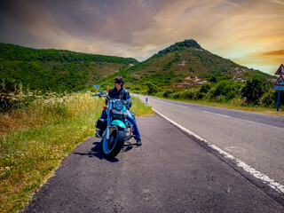 Biker sitting on his motorcycle on the side of the road