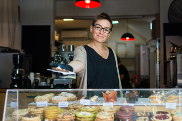 Window service clerk is offering a client a cookie