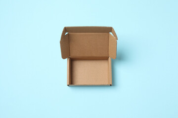 Open cardboard box on color background