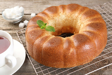 Freshly baked sponge cake, sugar cubes and tea on wooden table, closeup